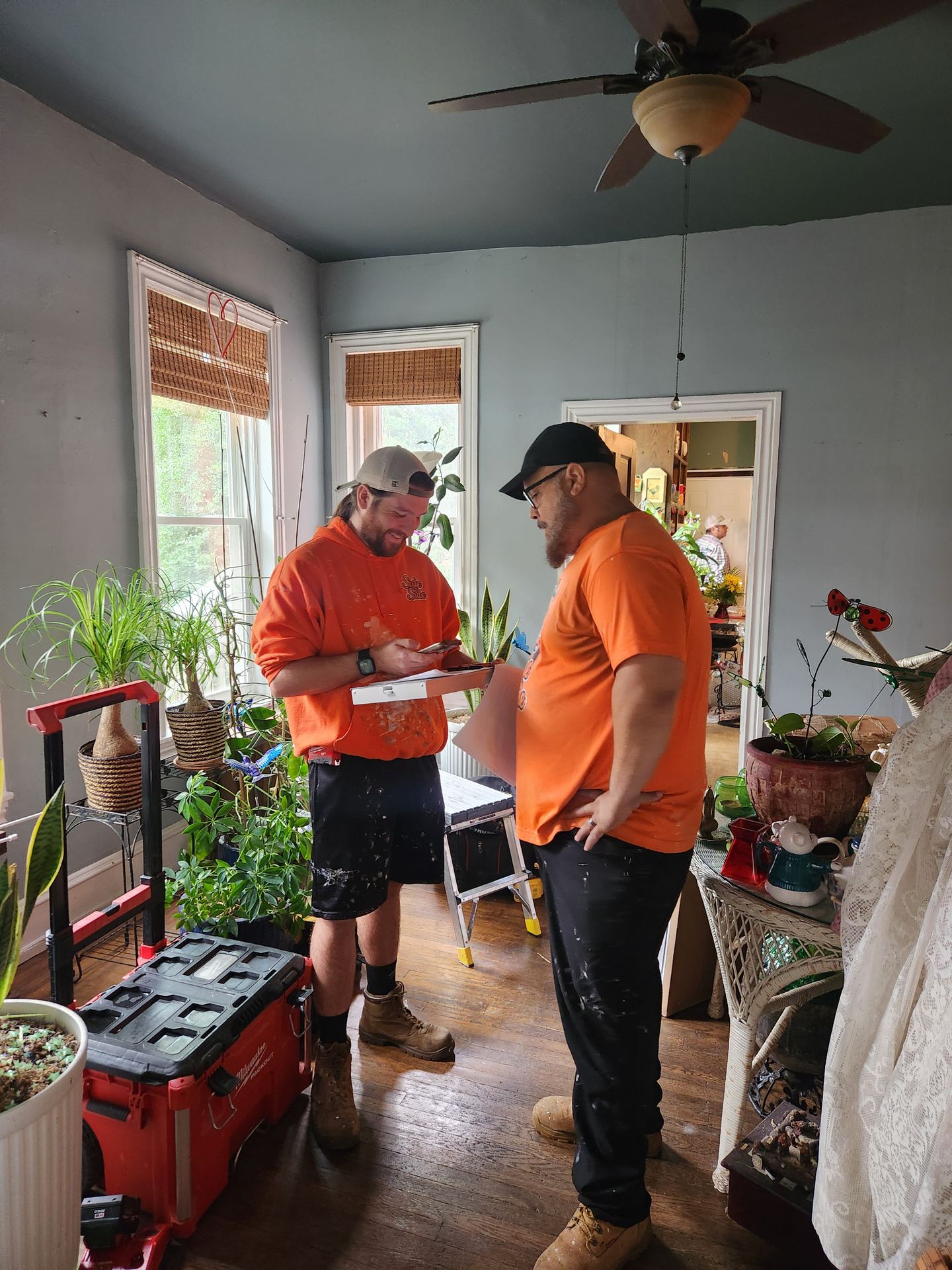 Two Side by Side crew members reviewing the scope of work inside a client's home
